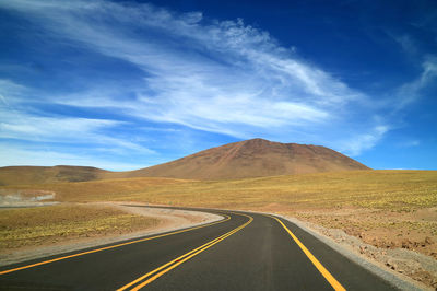 Empty road along landscape against sky