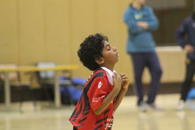 Side view of a boy standing against yellow wall