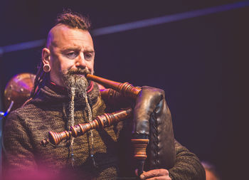 Mature man playing bagpipes on stage