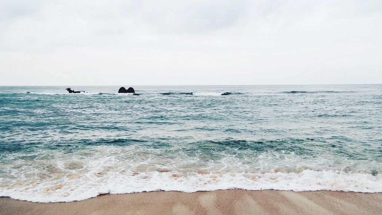 sea, horizon over water, water, beach, sky, shore, scenics, tranquil scene, wave, sand, tranquility, beauty in nature, nature, nautical vessel, surf, idyllic, seascape, vacations, boat, incidental people