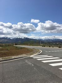 Road by mountains against sky