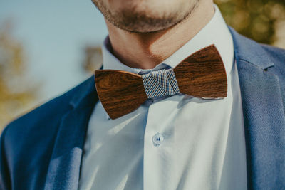 Close-up midsection of man wearing wooden bow tie