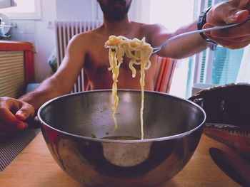 Midsection of man having food at home