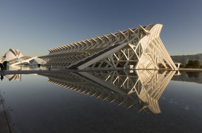 Reflection of built structure in water against clear sky