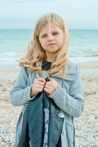 Portrait of young woman standing at beach