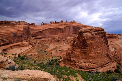 Rock formations on landscape against cloudy sky