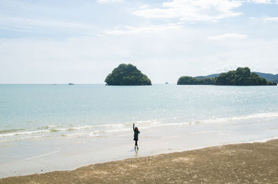 Man standing on beach against sky