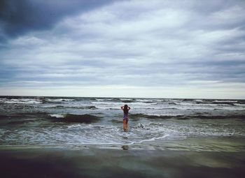 Man standing on beach against sky