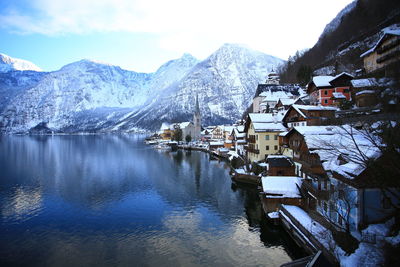 Houses and snowcapped mountain by river