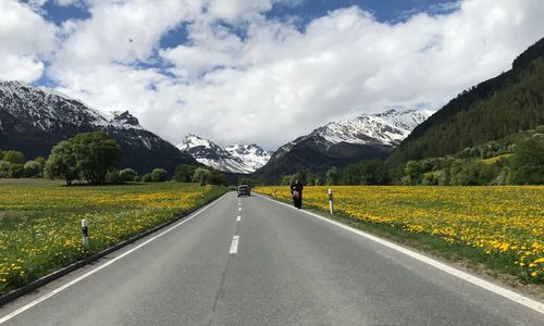 Road leading towards mountains against sky