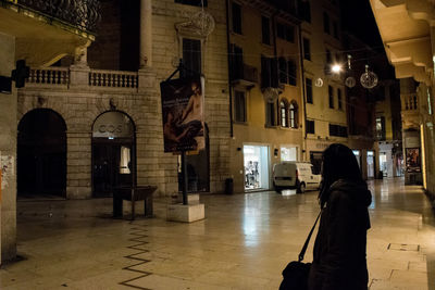 Man photographing in city at night