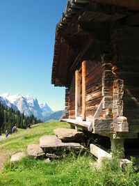 Built structure on field by mountains against sky