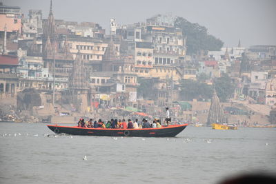 Boats in ganges against buildings in city