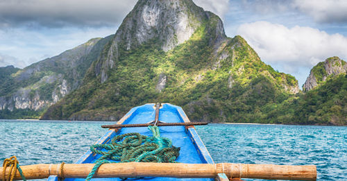 Scenic view of sea by mountains against sky