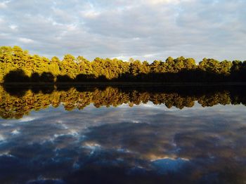 Scenic view of calm lake against cloudy sky