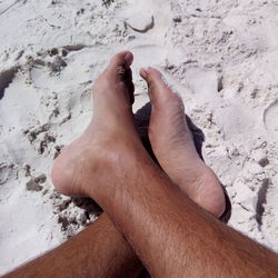 Low section of woman legs on sand at beach