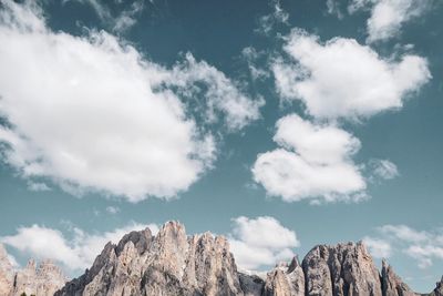 Low angle view of clouds over mountain against sky