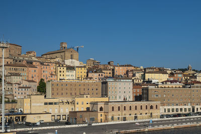 Buildings in city against clear blue sky