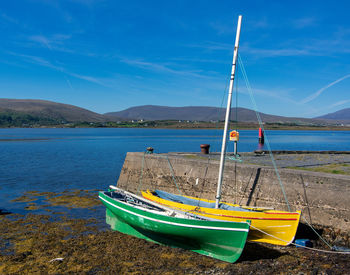 Boat moored on beach against sky