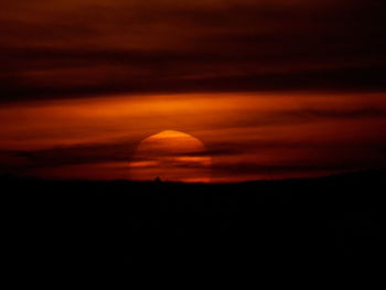 Scenic view of silhouette landscape against orange sky