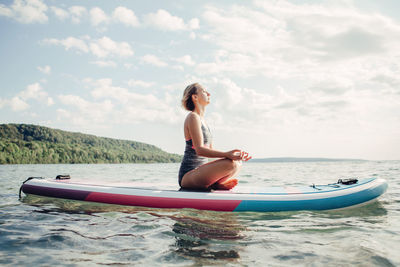 Young woman in sea against sky