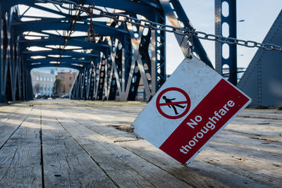 Warning sign hanging on abandoned bridge