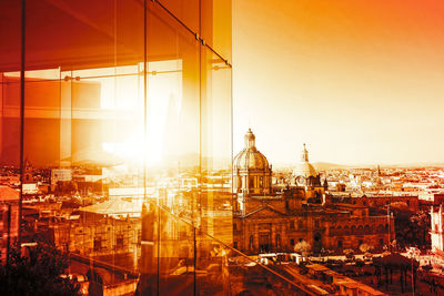 View of buildings in city at sunset