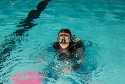 Portrait of young woman swimming in pool