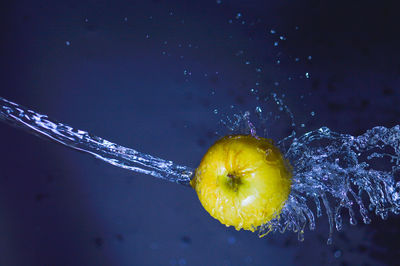 Close-up of water splashing on apple