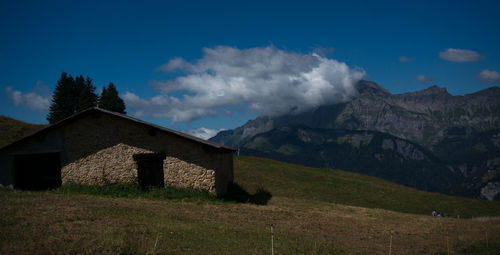 Scenic view of house and mountains against sky