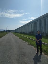 Man standing on road against sky