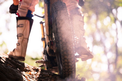 Low section of man standing on bicycle