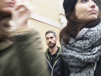 Portrait of young couple standing against wall