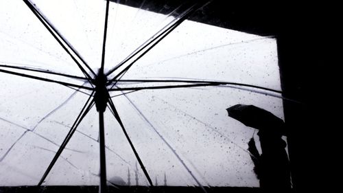 Low section of silhouette person standing on wet floor