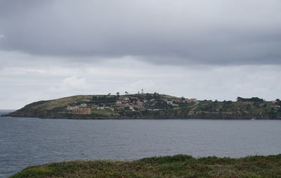 Scenic view of sea by buildings against sky