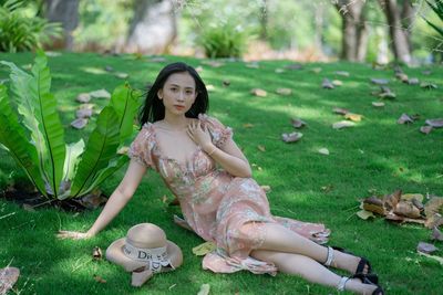 Portrait of young woman sitting on field