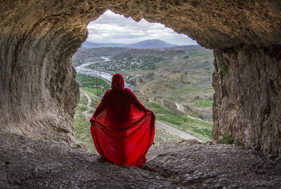 Rear view of woman standing on rock