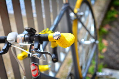 Close-up of yellow bicycle on metal in city