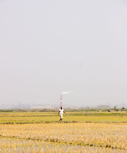 Full length of man standing on field against clear sky