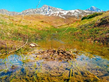 Scenic view of lake by mountain against sky