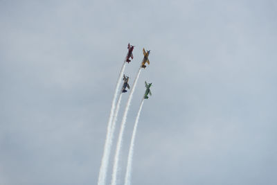 Low angle view of airplanes flying against sky during air show