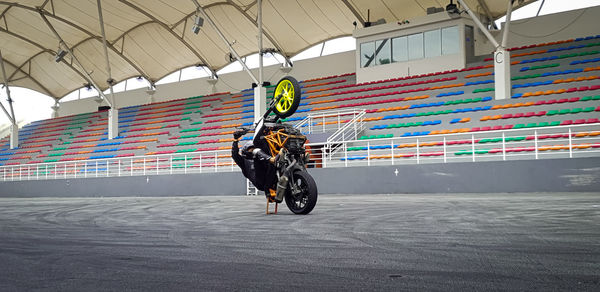 Full length of biker performing stunt in stadium