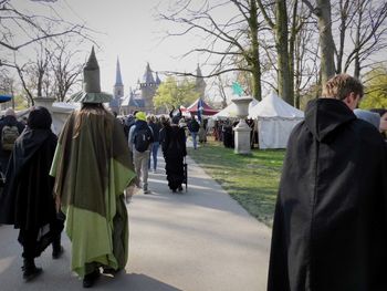 Rear view of people in front of city