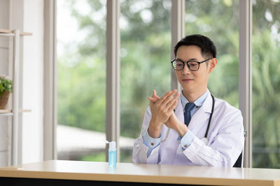 Portrait of young man wearing eyeglasses on table