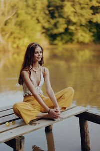 Young woman sitting on pier