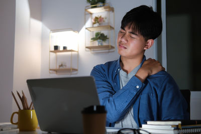 Man looking at camera while sitting on table