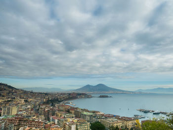 Cityscape by sea against sky