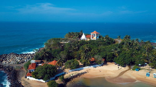 High angle view of buildings by sea against blue sky