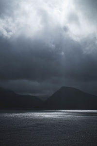 Scenic view of sea and mountains against sky