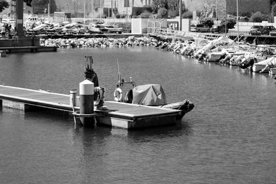 Boats moored in river against vehicles on road